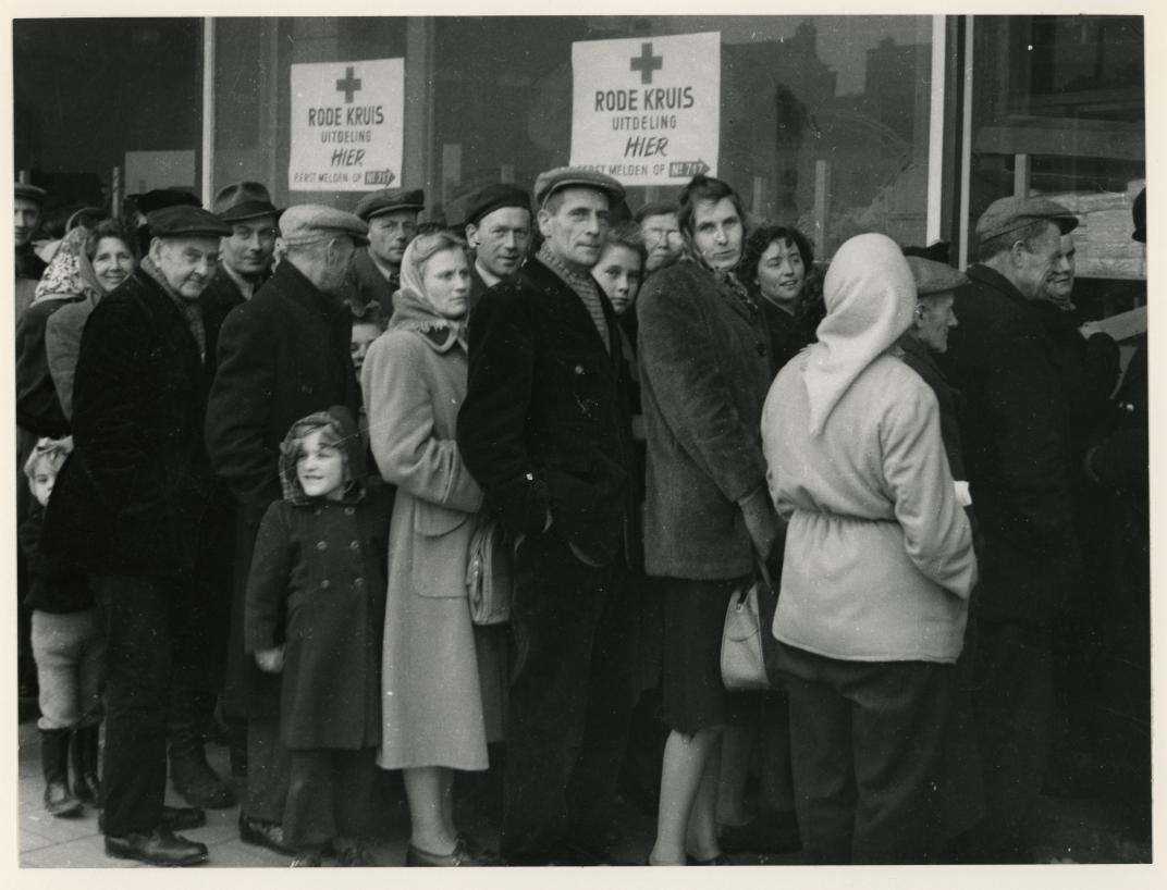 Mensen in de rij voor een uitdeelpost. Collectie 4282, nummer 1977-3957. Fotograaf Johannes van Rhijn
