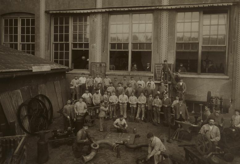 Metaalbewerkers, machine- en pijpmakers, personeel van de brouwerij, opgesteld voor één van de gebouwen op het terrein van de Oranjeboombrouwerij. 1902. NL-RtSA_4100_2007-2898-4